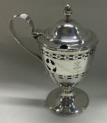 An 18th Century silver vase shaped mustard with pierced and engraved decoration. London 1780.
