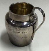 A small tapering silver cream jug with gilt interior.
