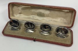 A set of four silver and tortoiseshell inlaid menu holders decorated with birds.