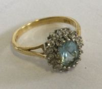 A good 18 carat gold aquamarine and diamond oval cluster ring.