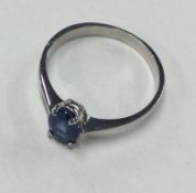 A small blue stone ring in white gold claw mount.