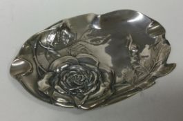 A novelty silver dish embossed with flowers and engraved with vines.