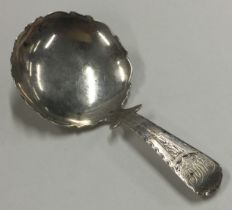 A large George III silver caddy spoon with bright cut decoration to handle and border.