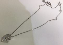 A heavy diamond princess cut pendant on fine link chain.