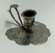 A George III silver chamberstick chased with leaf decoration.