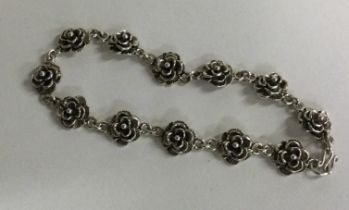 An attractive silver bracelet decorated with flowers.