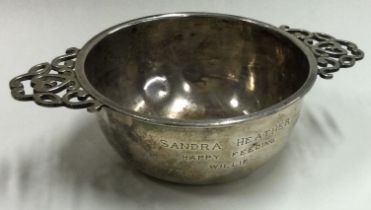 A heavy silver two handled bowl with scroll decoration.