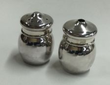 A cased pair of silver salt and pepper condiments.