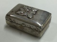 A heavy silver hinged pill box with chased decoration.