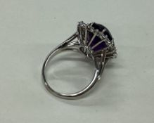A large amethyst and diamond oval cluster ring inn
