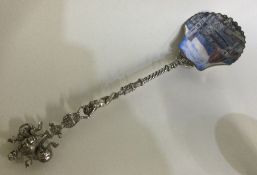 A large Continental silver and enamelled figural spoon depicting a temple scene.