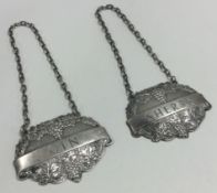 A pair of cast silver wine labels for 'Sherry' and 'Gin' with vine decoration.