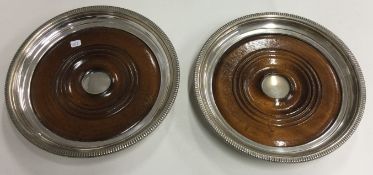 A large pair of silver mounted wooden magnum coasters.