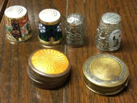 A collection of four bone china thimbles together with a silver plated enamelled box.