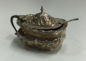 A chased silver and glass mustard pot. Sheffield 1909.