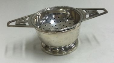 A silver tea strainer on stand. Birmingham.