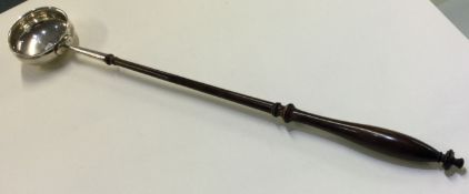 An early Georgian silver toddy ladle.