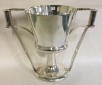 A large silver cup with handles embossed with beetles.