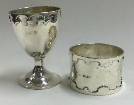 An Art Deco silver egg cup and napkin ring set.