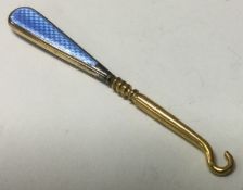 A silver gilt and blue enamelled hook.