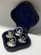 A set of four silver menu holders depicting thistles and flowers.