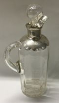 A large silver and glass whisky jug and stopper.