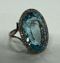 A large single stone aquamarine and diamond cluste