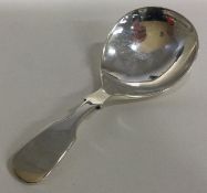 A modernistic silver caddy spoon.