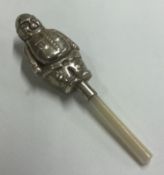 A silver rattle in the form of a person with MOP handle.