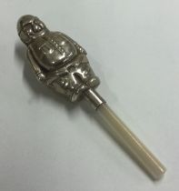 A silver rattle in the form of a person with MOP handle.