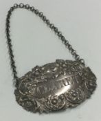 A large chased Victorian silver wine label for 'Claret' embossed with flowers. London 1841.