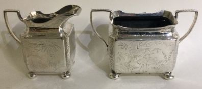 A Victorian silver Aesthetic movement sugar and cream engraved with birds.