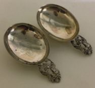 A heavy pair of Continental silver caddy spoons pierced with birds.
