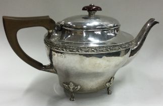 A E JONES: A silver teapot on feet. Birmingham 1919.