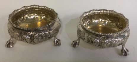 A pair of Victorian chased silver salts on feet. London 1862.