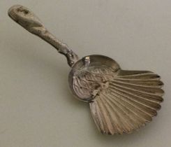 A Georgian silver fluted caddy spoon with bright cut decoration.