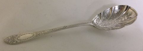 An engraved silver serving spoon. London 1909.