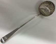 A large dragon crested Georgian silver bottom marked soup ladle with fluted bowl. London 1772.