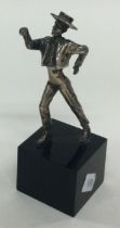 A silver figure of a man on plinth.