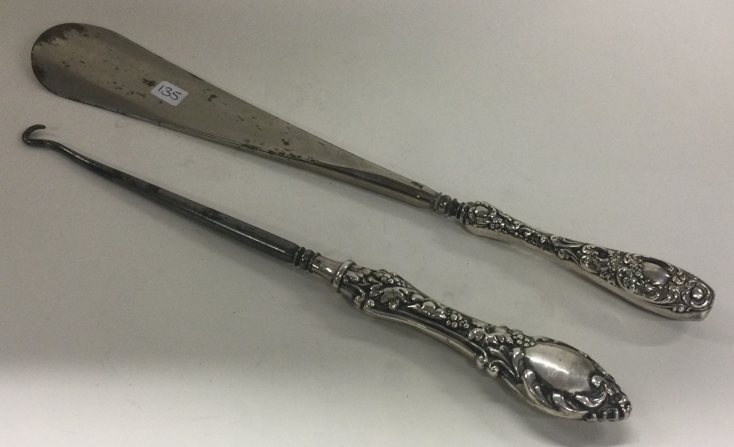 A shoe horn and button hook with grape vine and floral decoration. Birmingham 1902.
