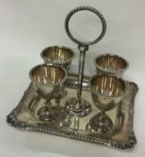 A silver four piece cruet on stand with shell border. Sheffield 1904. By Henry Aitken.