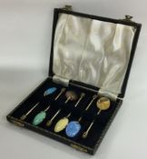 A set of six silver plated enamelled spoons.