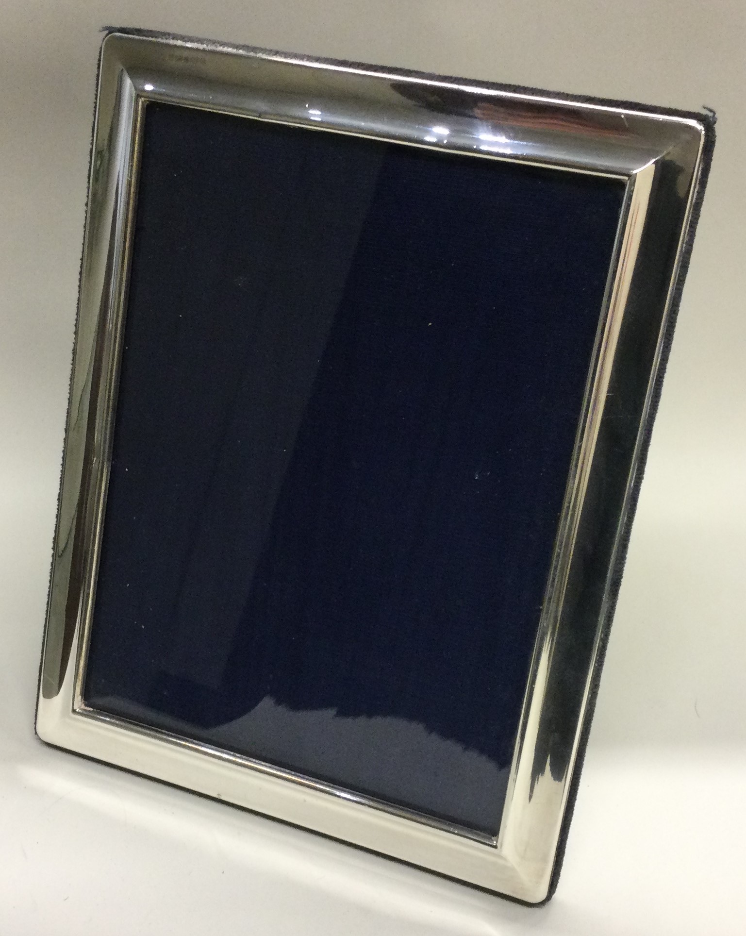 A large plain silver picture frame with moulded rim.