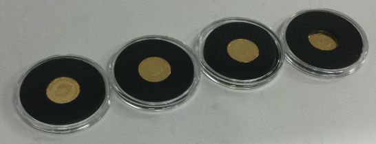 A group of four 22 carat gold proof coins.