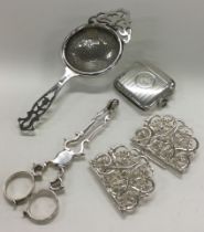 A pair of Georgian silver sugar nips together with a nurses buckle, tea strainer etc.