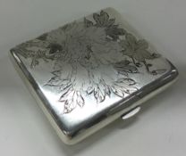 A Japanese silver and Niello cigarette case engraved with leaves and flowers.
