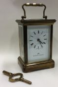 A brass carriage clock with white enamelled dial.