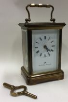 A brass carriage clock with white enamelled dial.