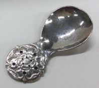 GUILD OF HANDICRAFTS: A silver caddy spoon with floral and hammered decoration.