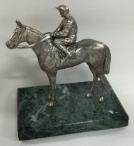 A silver figure of a jockey on horseback.